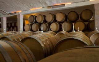 Inside the Lanzerac barrel maturation cellar, showing rows of traditional oak barrels used for ageing wine.